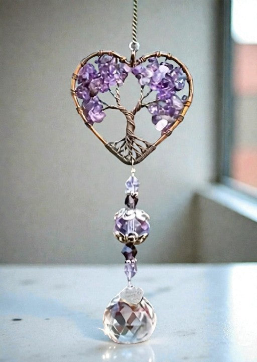 Decorative heart-shaped ornament with purple crystals and a clear crystal drop on a neutral background.