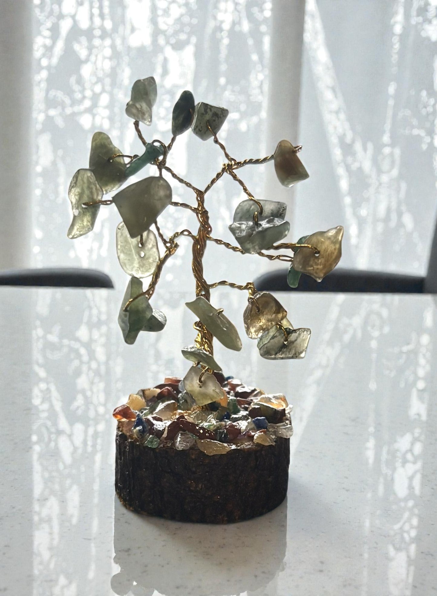 Decorative stone tree with green and brown stones on a white background