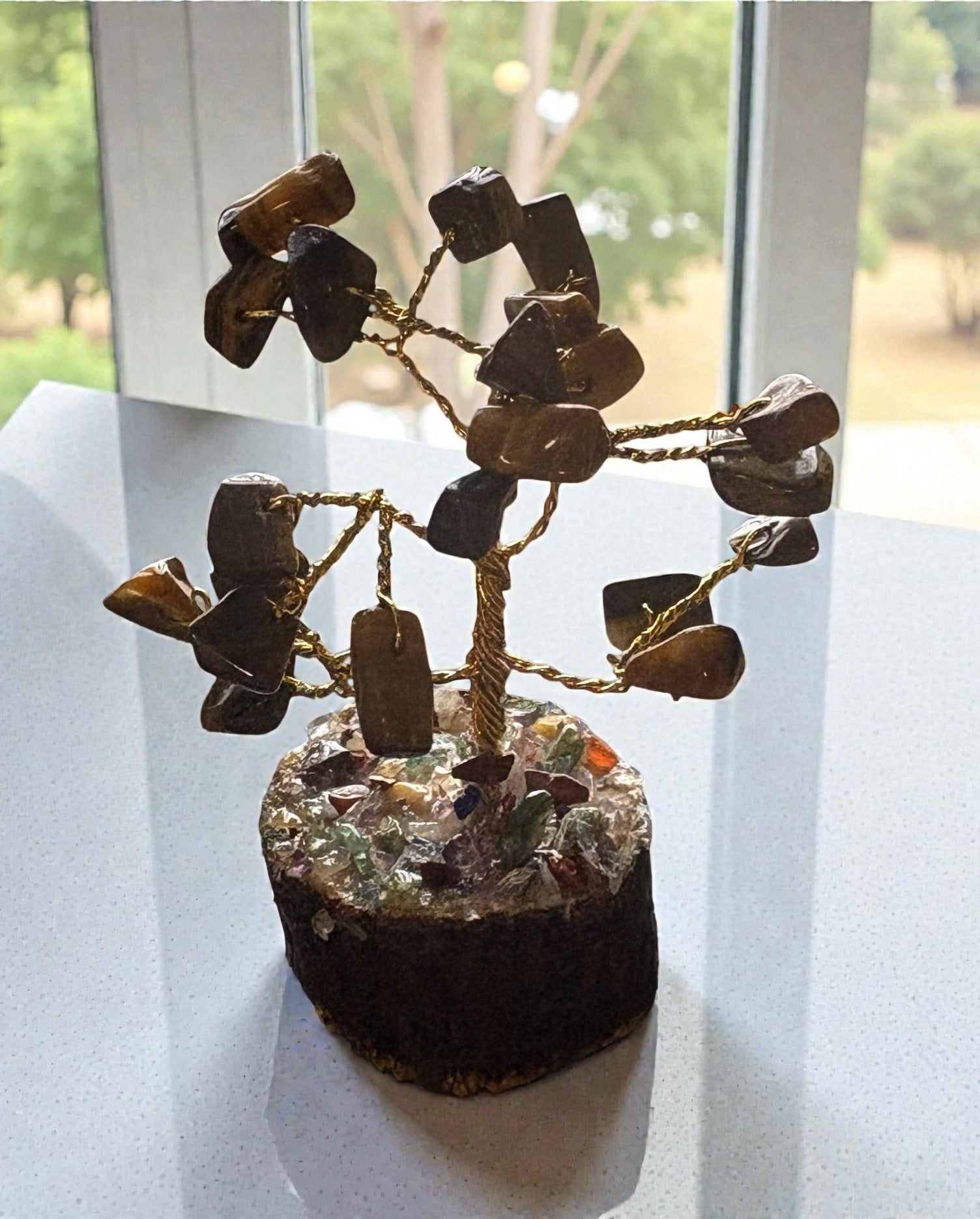 Decorative stone tree on a round base with a window in the background
