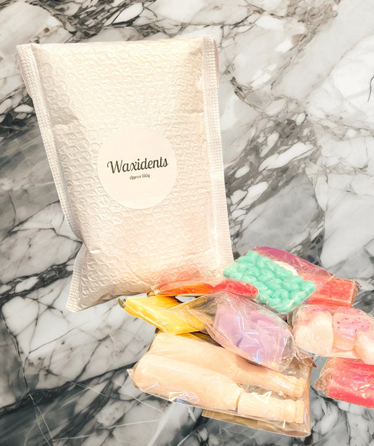 A bag labeled 'Waxidents' containing various colored wax tarts spread out on a marble surface.