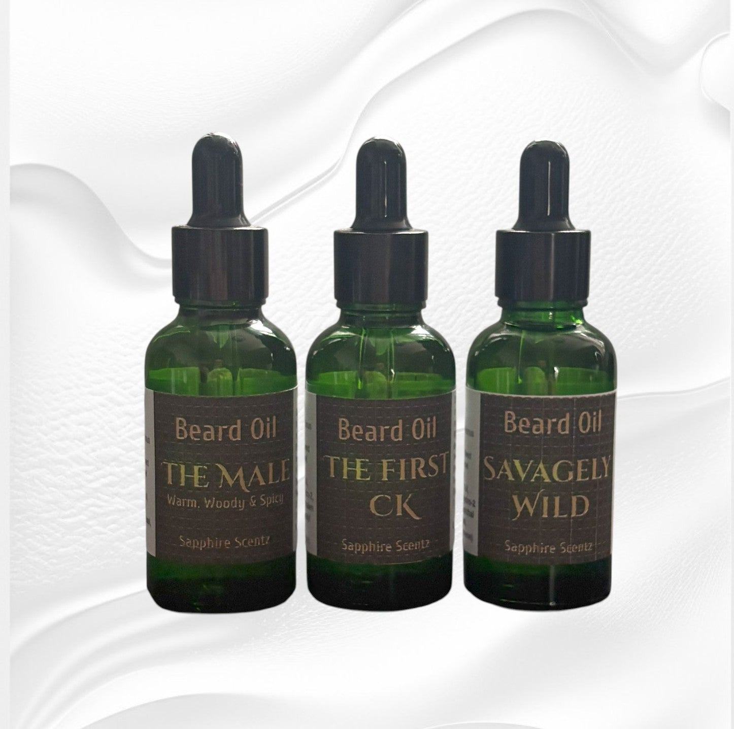 Three bottles of beard oil with labels on a white background