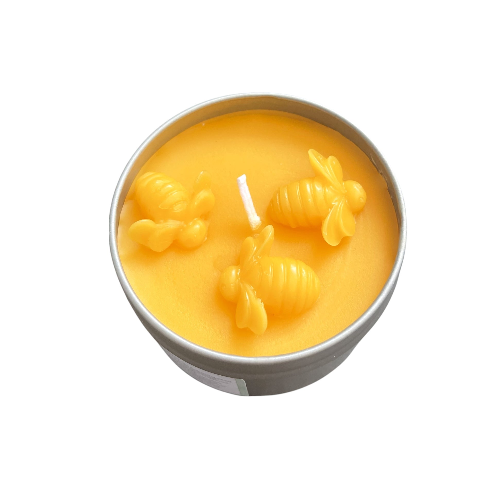 Yellow candle with bee designs in a tin container on a white background