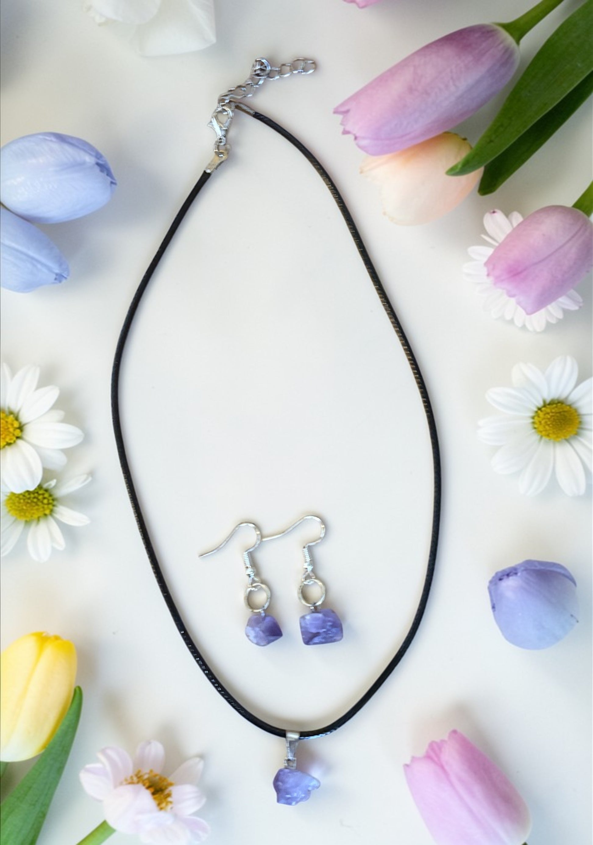 Jewelry set with necklace and earrings on a white background with flowers