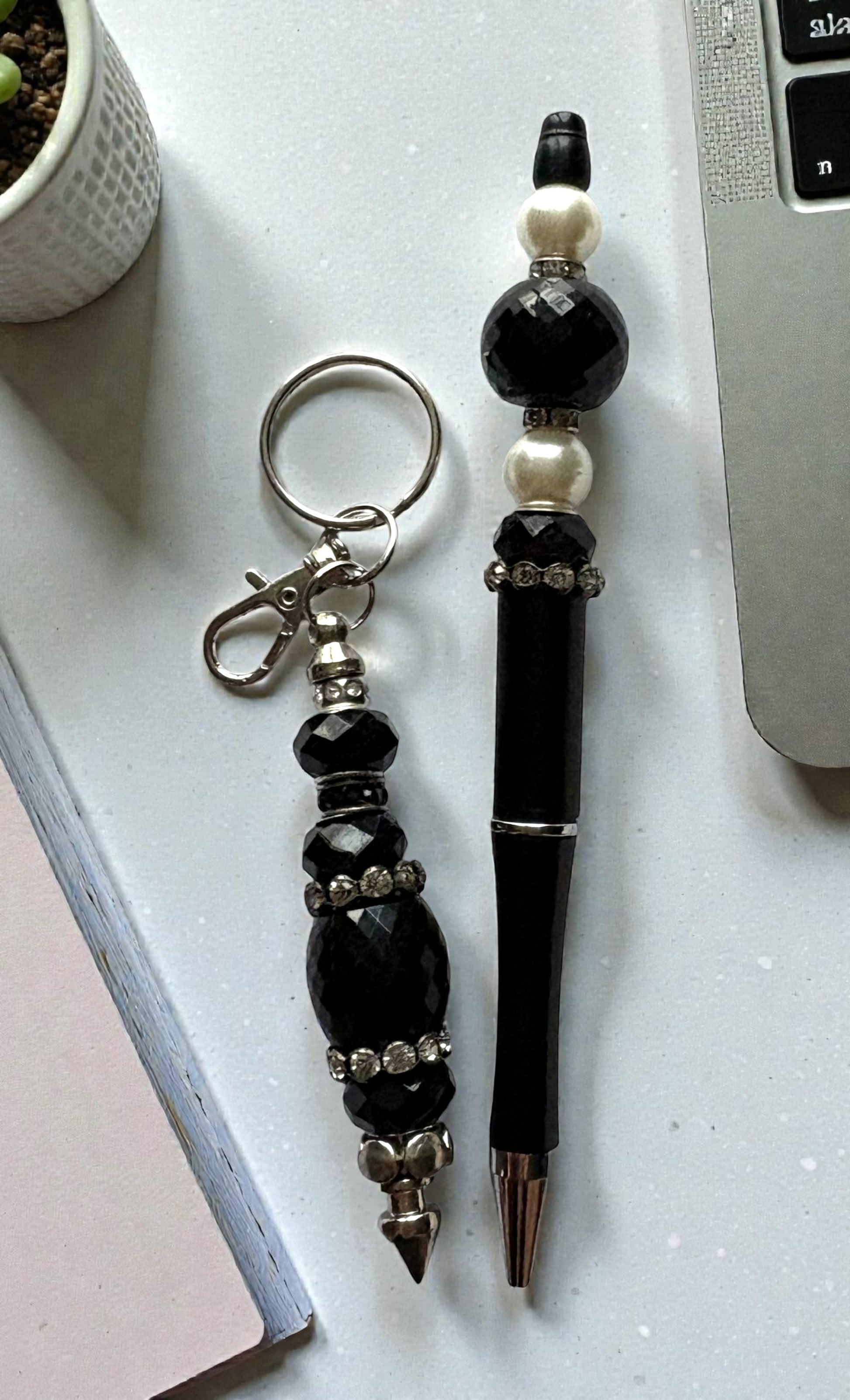 Black beaded keychain and pen on a light surface