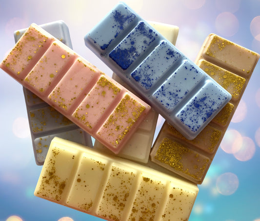 A collection of snap bars with varying colors and textures, possibly scent-infused wax tarts designed to be used with a warmer for fragrance.