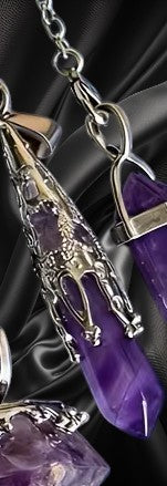 Decorative keychain with purple and silver design on a dark background