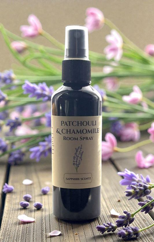 Room spray bottle labeled 'Patchouli & Chamomile' with lavender flowers in the background