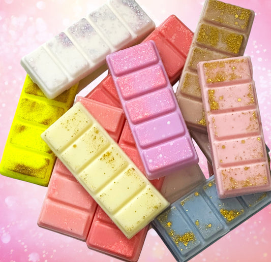 A collection of colorful snap bars with a glittery appearance, each bar is cut into five sections. The bars are displayed against a pink background.