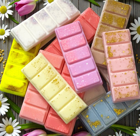 Colorful wax melts in molds with decorative flowers on a wooden surface