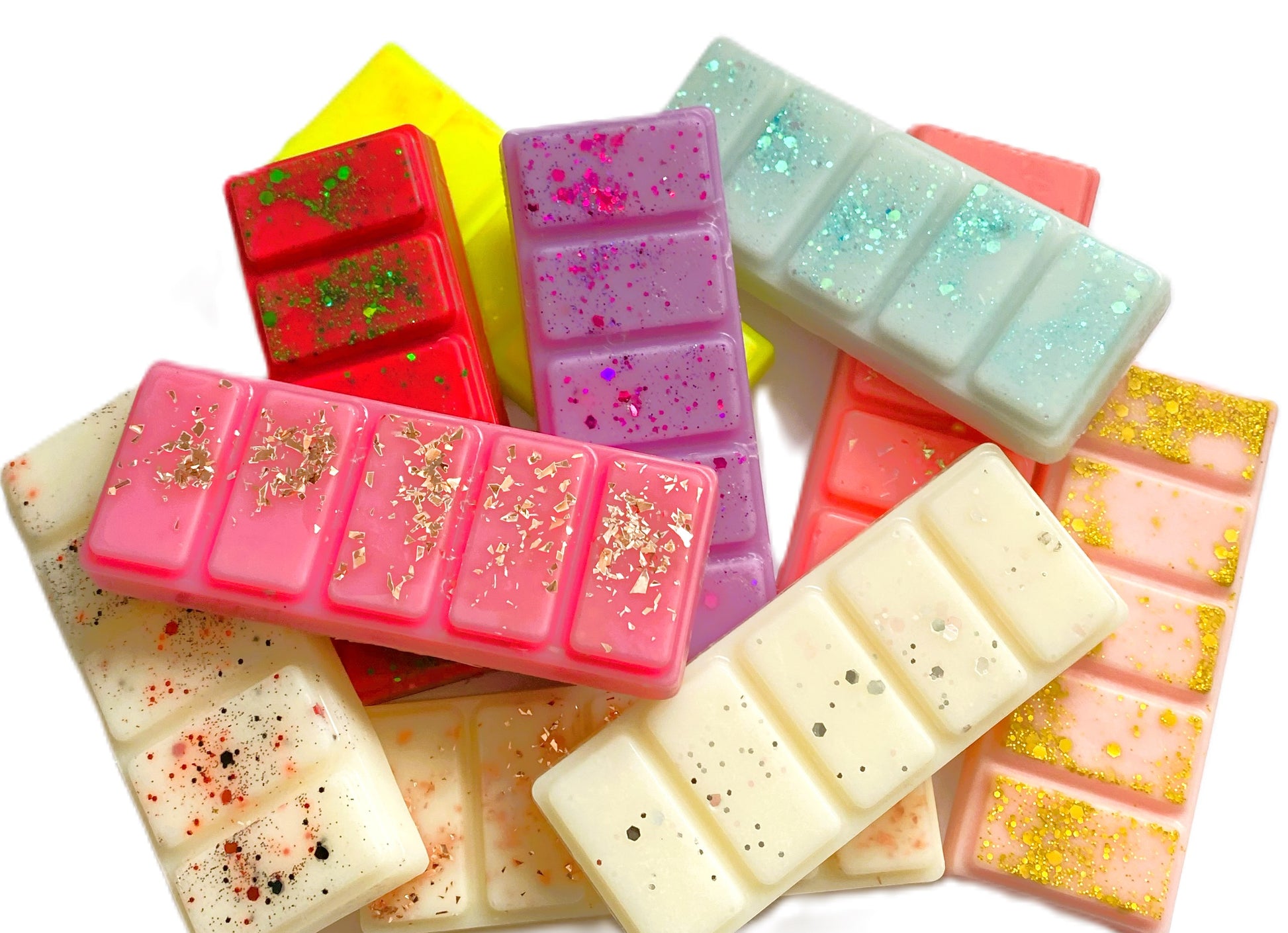 Assorted colorful wax melts with glitter and speckles on a white background